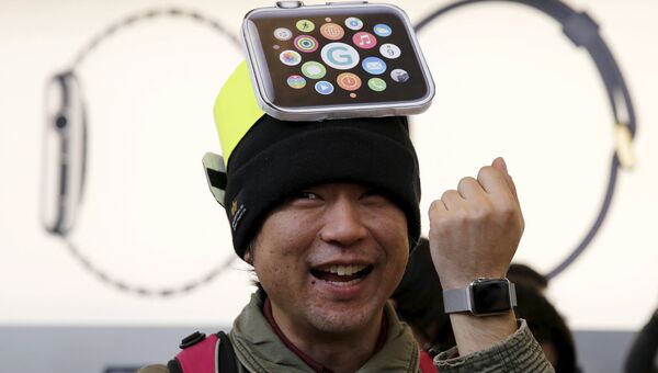 Счастливый покупатель примеряет часы Apple во время демонстрации в одном из Apple Store, Токио. Апрель 2015