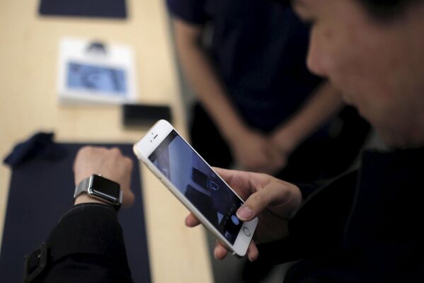 Покупатель примеряет часы Apple во время демонстрации в одном из Apple Store, Шанхай. Апрель 2015
