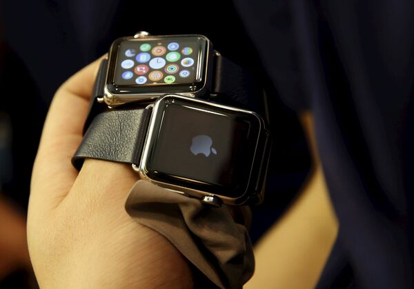 Сотрудник Apple Store в Пекине демонстрирует часы Apple. Апрель 2015