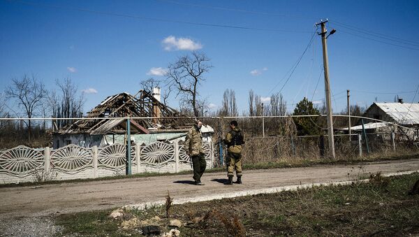 Ополченцы ДНР на фоне разрушенных построек в поселке Спартак в Донецкой области. Архивное фото