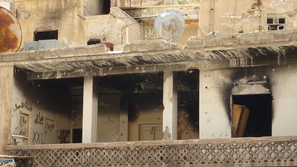 Пострадавшее от боевых действие здание в сирийском городе Маалюля в 55 км от Дамаска