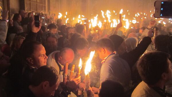 Паломники с Благодатным огнем в храме Воскресения Христова (Гроба Господня) в Иерусалиме. Архивное фото