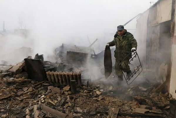 Житель поселка Шира в Хакасии разбирает металлолом в своем доме после разрушительных пожаров. Апрель 2015