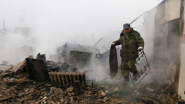 Житель поселка Шира в Хакасии разбирает металлолом в своем доме после разрушительных пожаров. Апрель 2015
