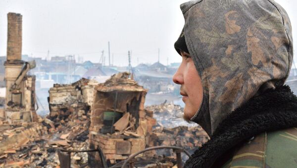 Мужчина смотрит на последствия природных пожаров в селе Шира Республики Хакасия