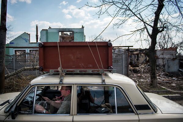 Житель покидает место боевых действий в районе аэропорта Донецка. Апрель 2015