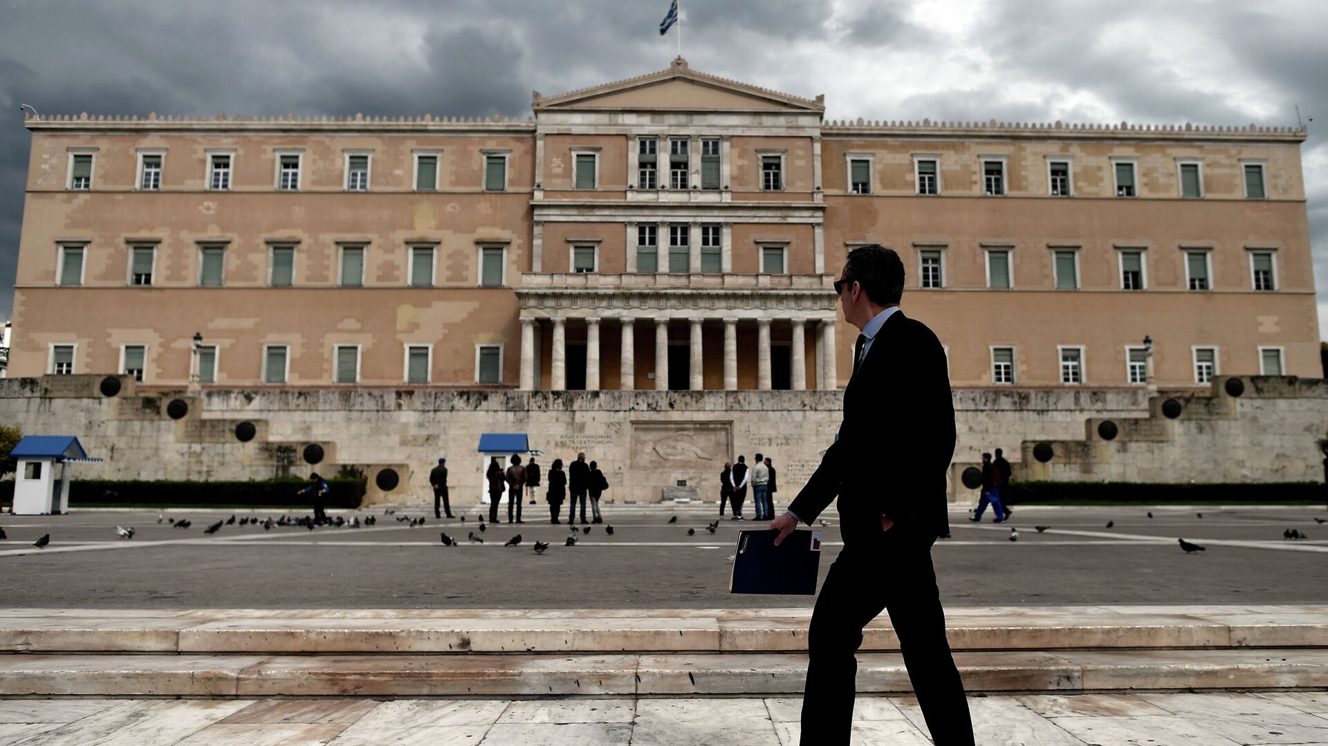 Мужчина проходит возле здания парламента Греции в Афинах - РИА Новости, 1920, 12.05.2022