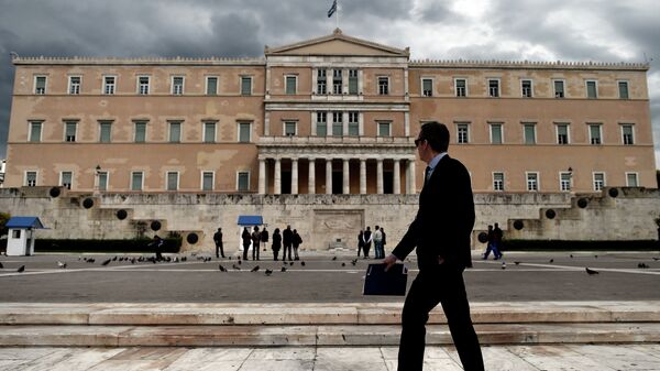Мужчина проходит возле здания парламента Греции в Афинах. Архивное фото