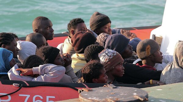 Нелегальные мигранты, спасенные после крушения судна в водах Ливии, на лодке береговой охраны Италии
