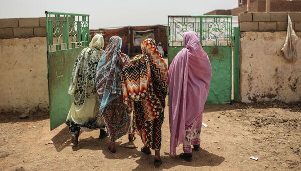Женщины покидают избирательный участок в первый день президентских и парламентских выборов в Судане
