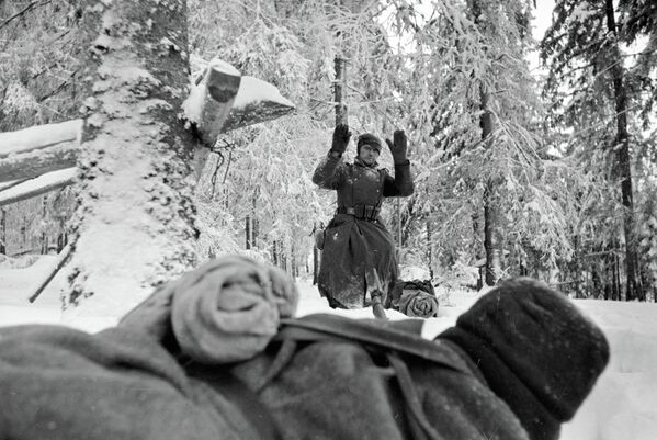 Немецкий солдат выходит из леса с поднятыми вверх руками