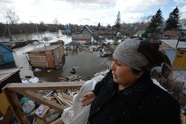 Местная жительница на крыльце второго этажа своего дома в дачном поселке на окраине Новосибирска, подтопленном талыми водами