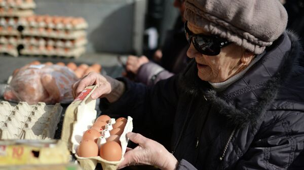 Пенсионерка покупает яйца на городской продовольственной ярмарке в Новосибирске. Архивное фото
