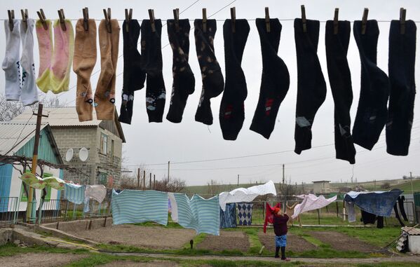 Женщина развешивает белье в Бердянске