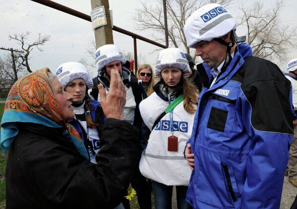 Жительница деревни Широкино разговаривает с представителем ОБСЕ Александром Хугом