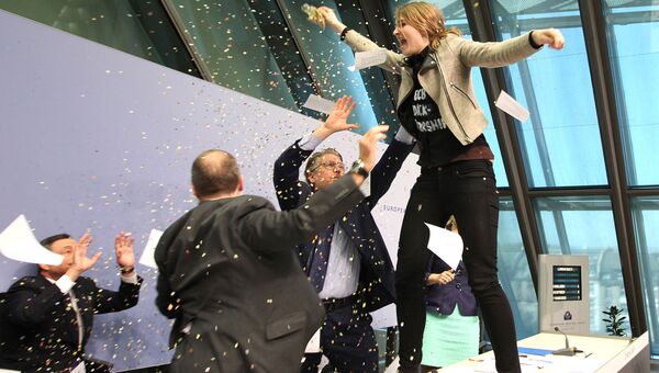 Активистка забралась на стол председателя ЕЦБ Марио Драги во время пресс-конференции
