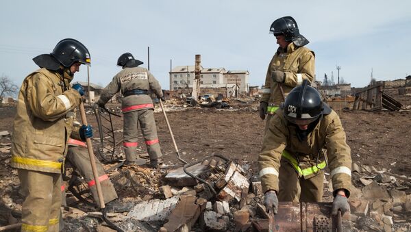 Сотрудники МЧС России работают в наиболее пострадавшем от пожара поселке Шира Республики Хакасия, 15 апреля 2015.