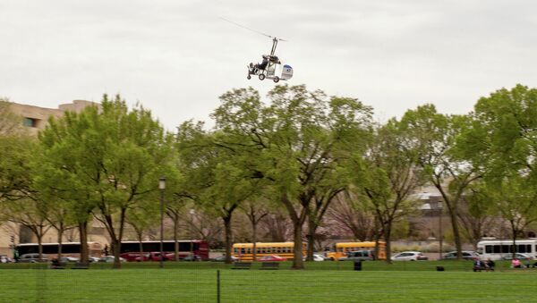 Одноместный вертолет приземляется на лужайку у главного здания конгресса США на Капитолийском холме в Вашингтоне. 15 апреля 2015