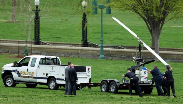Полицейские загружают на прицеп вертолет, приземлившийся на лужайке Капитолия в Вашингтоне