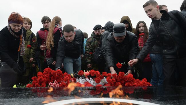 Жители Казани возлагают цветы к вечному огню на площадке ЦПКиО имени М. Горького во время торжественного мероприятия Вахты Памяти-2015 