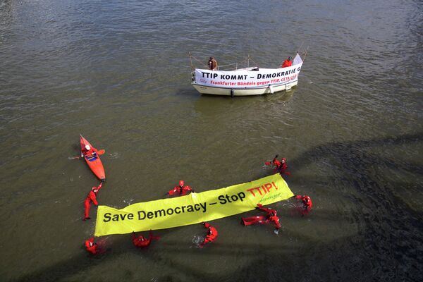 Участники франкфуртской акции протеста против соглашений о трансатлантической торговле в Европе - активисты движения Гринпис развернули баннер с лозунгом на реке Майн