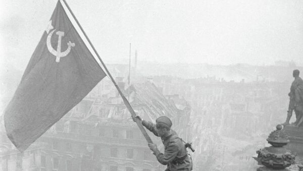 Боец Красной армии водружает Знамя Победы на поверженном рейхстаге. Архивное фото