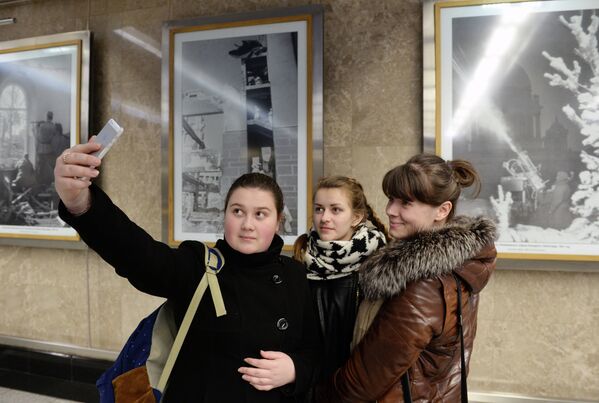 Девушки фотографируются на фоне архивных фотоснимков, сделанных во время ВОВ корреспондентами Совинформбюро