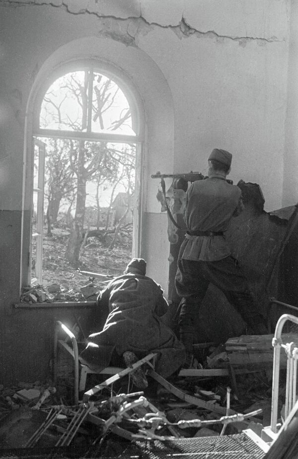 Бойцы ведут огонь по противнику из проема окна на окраине Новороссийска