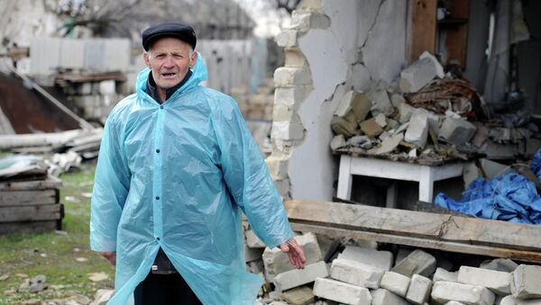 Житель поселка Никишино Донецкой области рядом с разрушенным домом