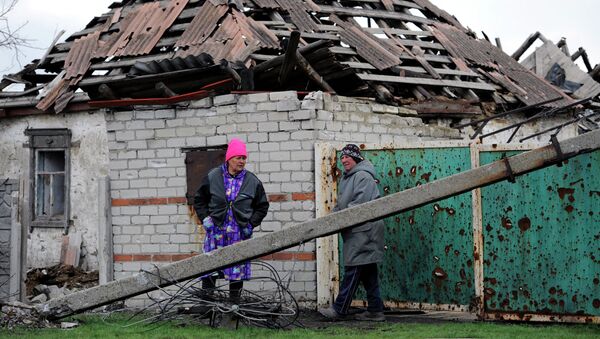 Жительницы поселка Никишино рядом с пострадавшим в результате обстрелов домом