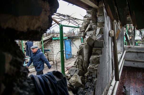 Мужчина рядом с разрушенным домом в селе Никишино Донецкой области