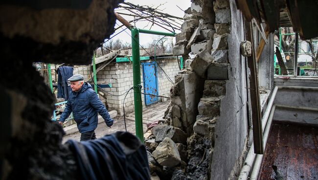 Мужчина рядом с разрушенным домом в селе Никишино Донецкой области. Архивное фото