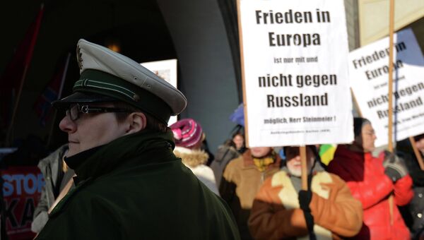 Полицейский на  многотысячной демонстрации на площади у городской ратуши в Мюнхене с лозунгами прекратить конфронтацию с Россией