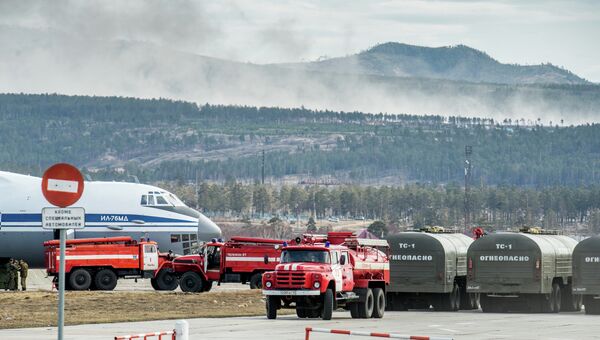 Пожарные автомашины и самолет ИЛ-76 МД во время подготовки к тушению лесных пожаров в Бурятии