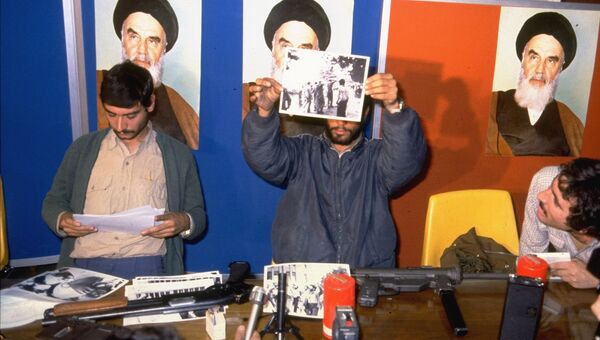 Иранские студенты держат фотографии захваченных заложников из посольства США в Иране. 5 ноября 1979
