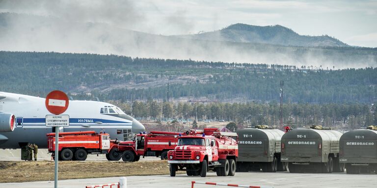 Пожарные автомашины и самолет ИЛ-76 МД во время подготовки для тушения лесных пожаров в Забайкальском крае