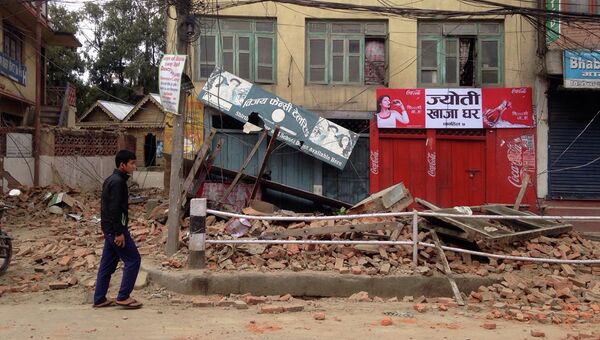 Прохожий возле поврежденных  в результате землетрясения домов в Катманду, Непал