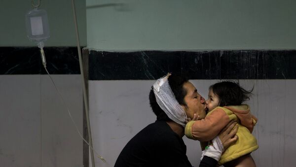Постадавший от землетрясения целует дочь в больнице Катманду, Непал. Архивное фото