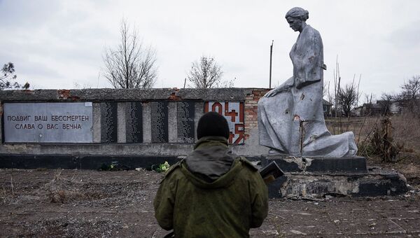 Боец ополчения ЛНР возле памятника павшим в годы Великой Отечественной войны, Луганская область. Архивное фото