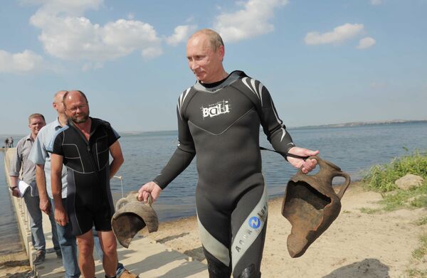 Владимир Путин держит в руках две древние амфоры, которые нашел на дне Таманского залива