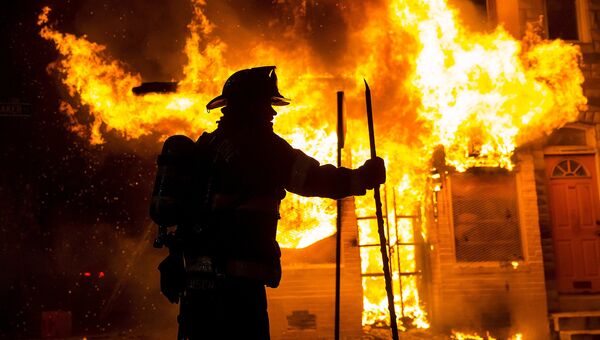 Беспорядки в Балтиморе. Пожарный у горящего дома