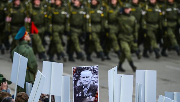 Военнослужащие и зрители во время военно-патриотической акции Под Знаменем Победы