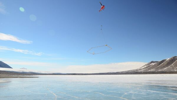 Вертолет с прибором SkyTEM пролетает над водами антарктического озера Фркселл