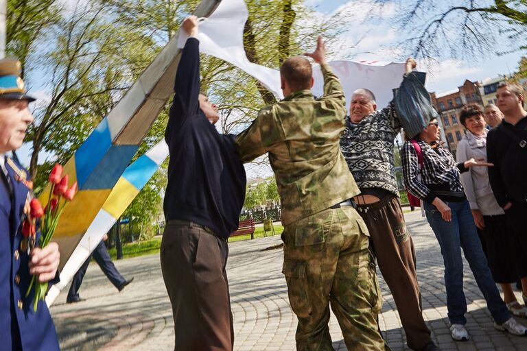 Проукраинский активист отбирает плакат у участников первомайского митинга в Харькове