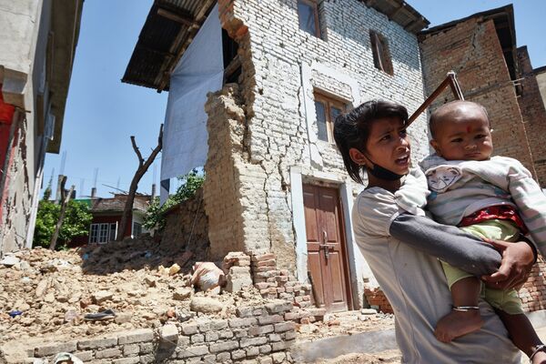 Местные жители на одной из улиц Катманду, разрушенной в результате землетрясения