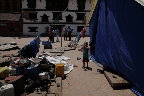Местные жители в центре столицы Непала Катманду на площади Дурбар, разрушенной в результате землетрясения