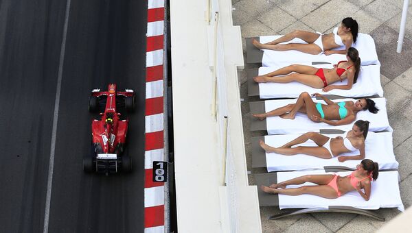Болид бразильского автогонщика Фелипе Масса проезжает мимо загорающих девушек в Монако в преддверии Гран-при Формулы-1. 2013 год