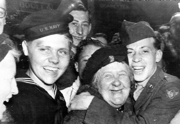 Американские солдаты обнимают англичанку во время празднования капитуляции Германии