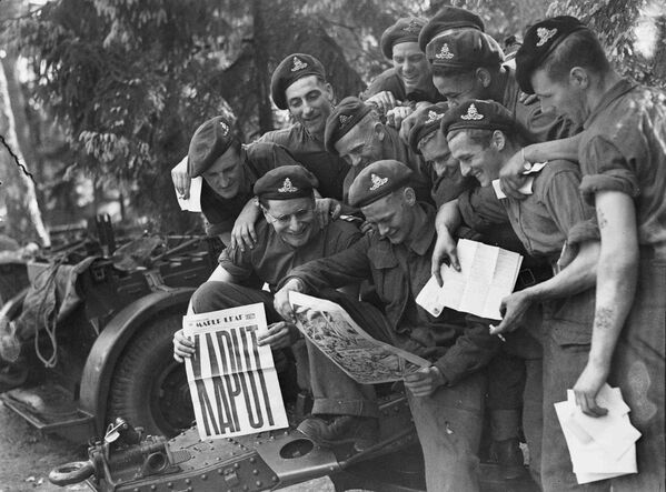Канадские военные читают газету после капитуляции Германии