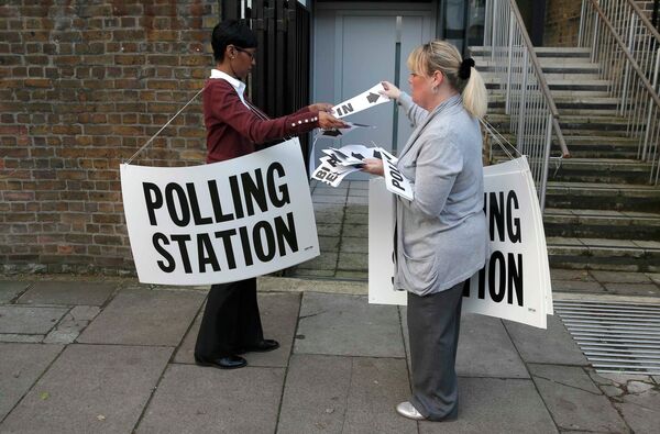 Сотрудницы избирательного участка в Ислингтоне размещают указатели